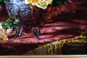 Detail of the red cloth with gold thread in Jules Leroy's still life painting.